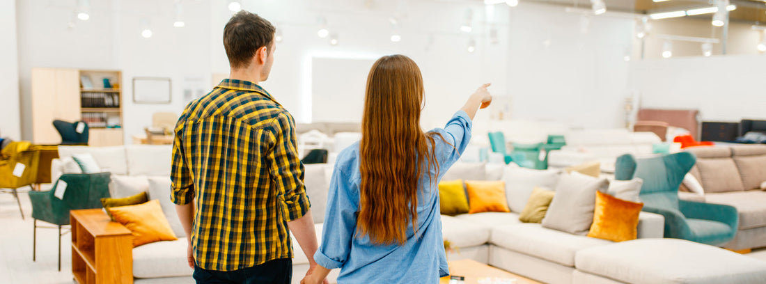 Pareja buscando dónde encontrar las mejores ofertas en muebles